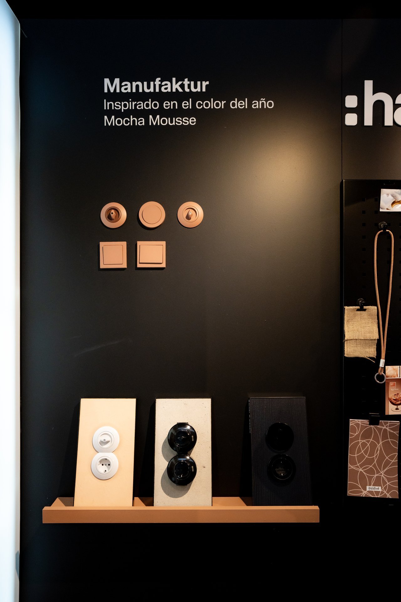 Exhibición de interruptores y enchufes Hager Manufaktur en tonos cobre, blanco y negro. Muestra la colección inspirada en Mocha Mousse.