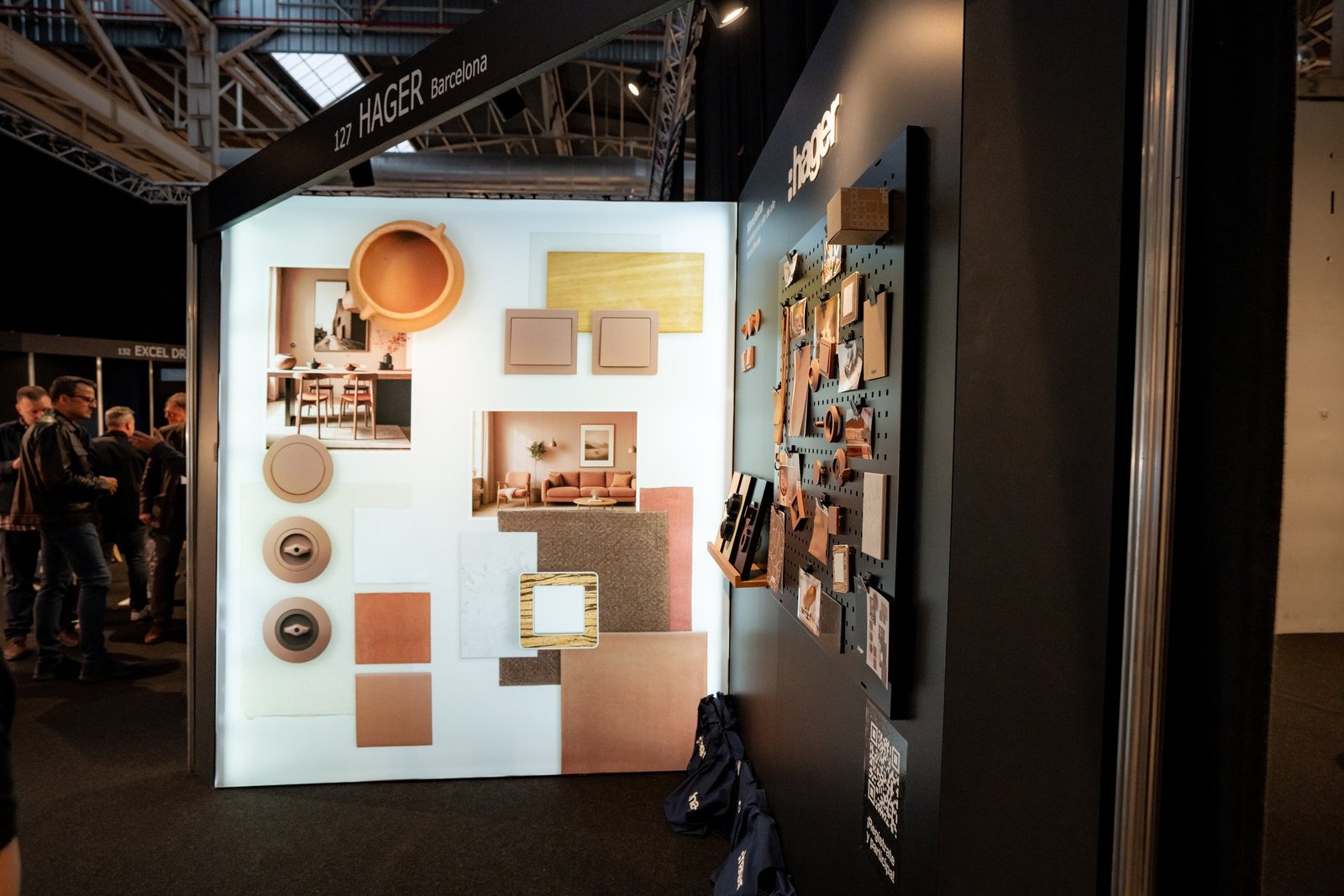 Stand de Hager en Architect & Work con exhibición de interruptores, enchufes y muestras de materiales en tonos tierra. Incluye fotos de i…