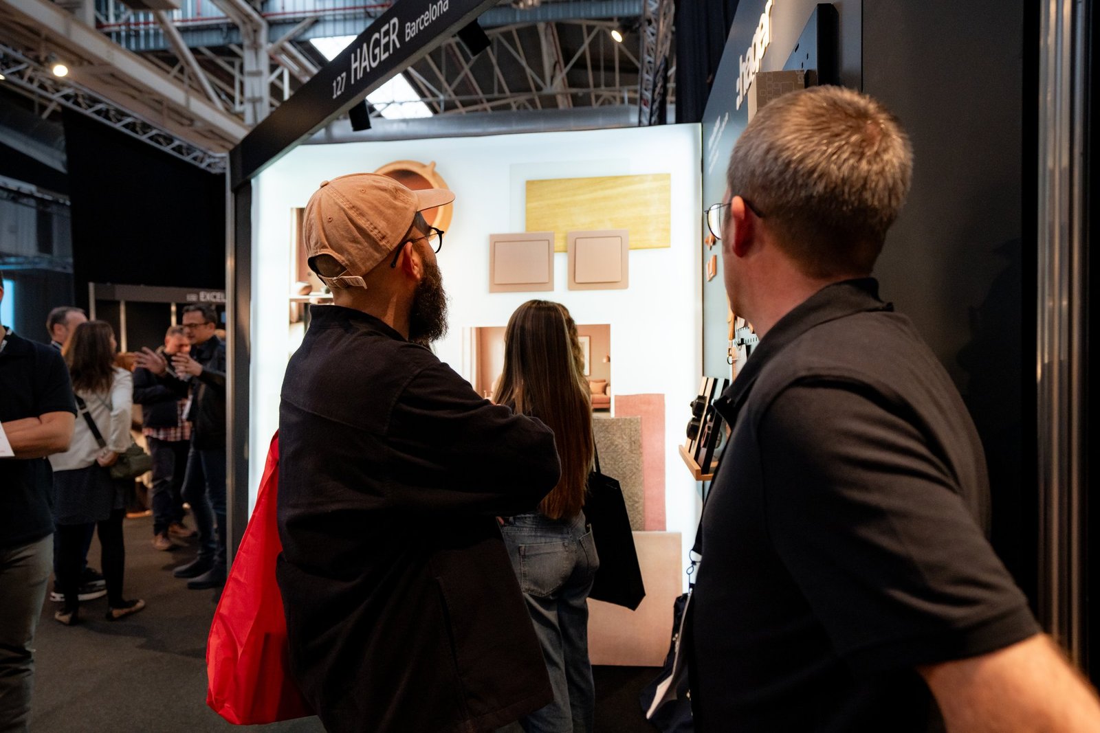 Visitantes observan muestras de diseño y soluciones en el stand de Hager en el evento Architect & Work.