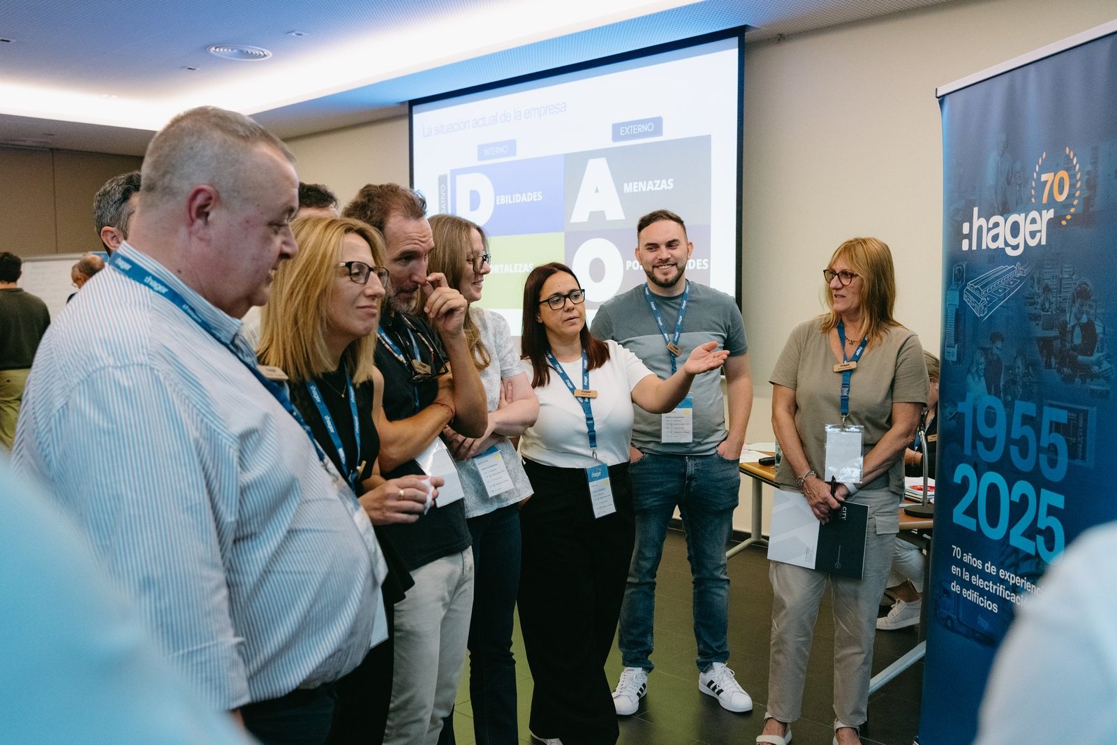 Grupo de empleados de Hager en un evento de teambuilding, atentos a una presentación de análisis DAFO en pantalla.